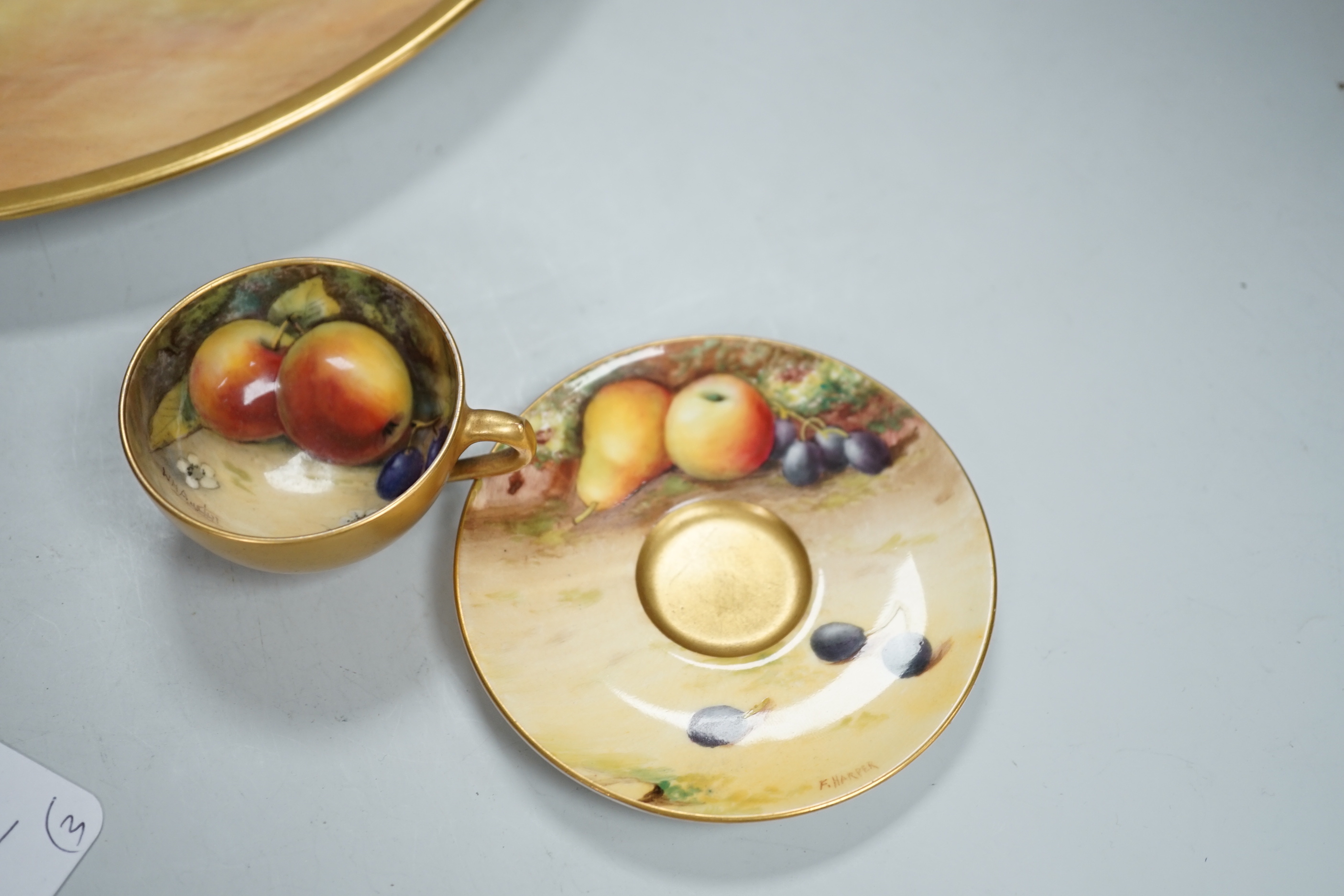 A large fruit painted dish by R. Budd and a Royal Worcester fruit painted miniature tea cup and saucer painted by F Harper and W H Austin, largest 32cm in diameter